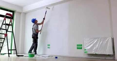 A man is painting a wall